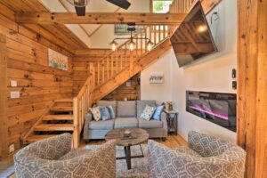 Cozy mountain cabin den with dramatic stairs, smart tv and electric fireplace